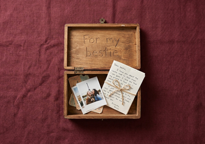 A wooden box with gifts inside on a Linen Background