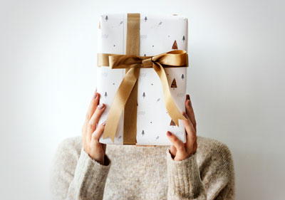 A woman with a gift covering her face.
