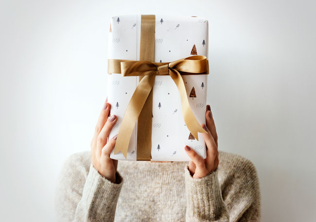 A woman with a gift covering her face.