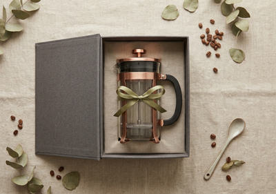 A French Press inside a gift box on a Linen Background