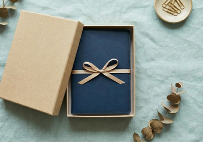 A book inside a gift box on a Linen Background